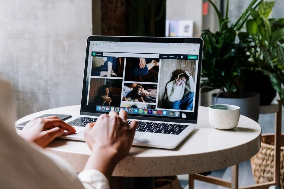 Two people browsing an online clothing shop on a laptop from an overhead view.