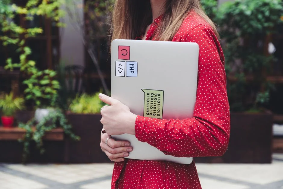 Woman using smartphone for online shopping with credit card in hand, festive background lighting.